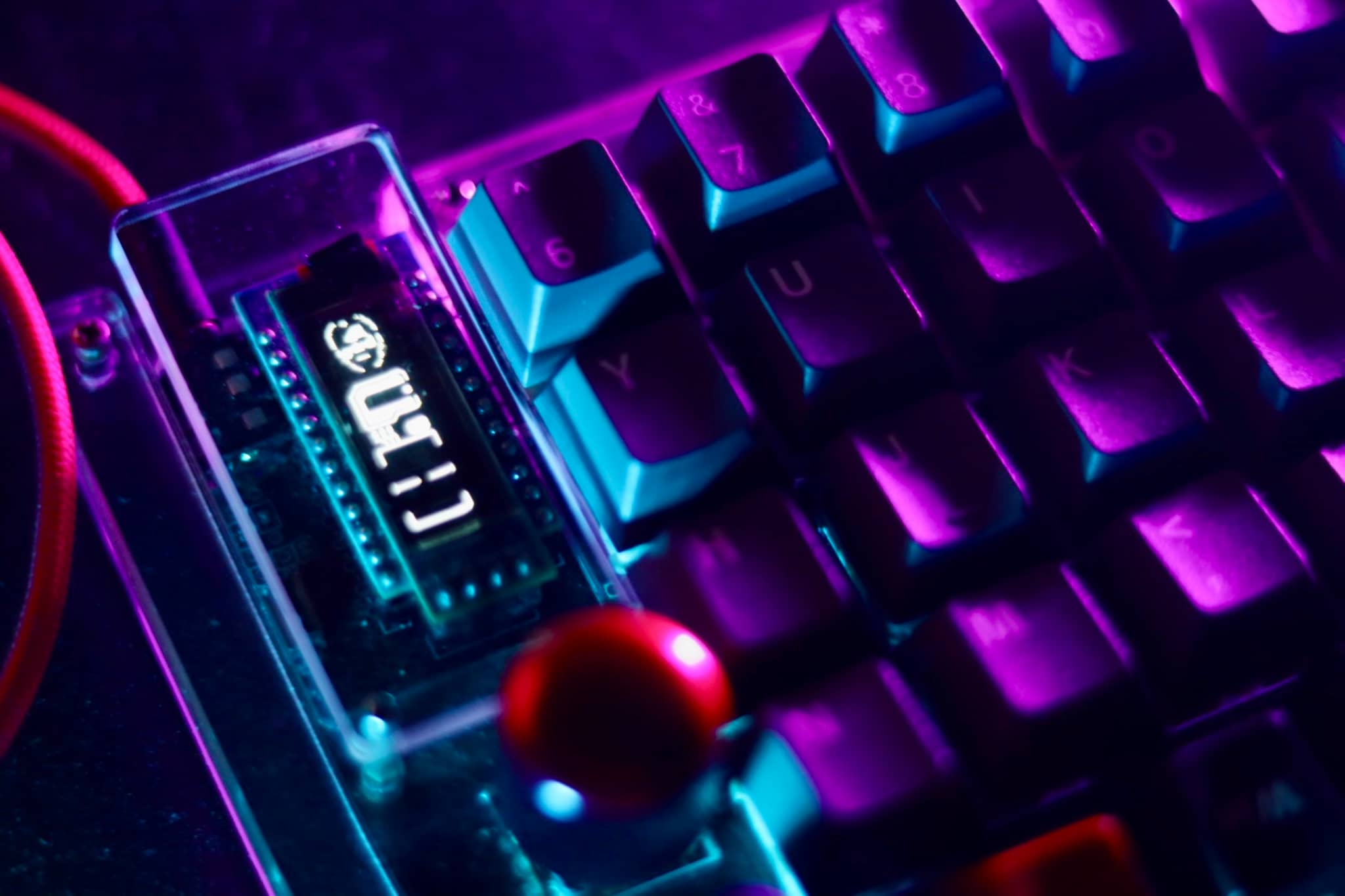 The image features an Arduino Uno board with a USB cable attached to it. The board has a digital display showing the number "1024". Surrounding the board, there are several colorful keyboard keys, suggesting that this setup may be related to a project involving electronics and computer hardware.
